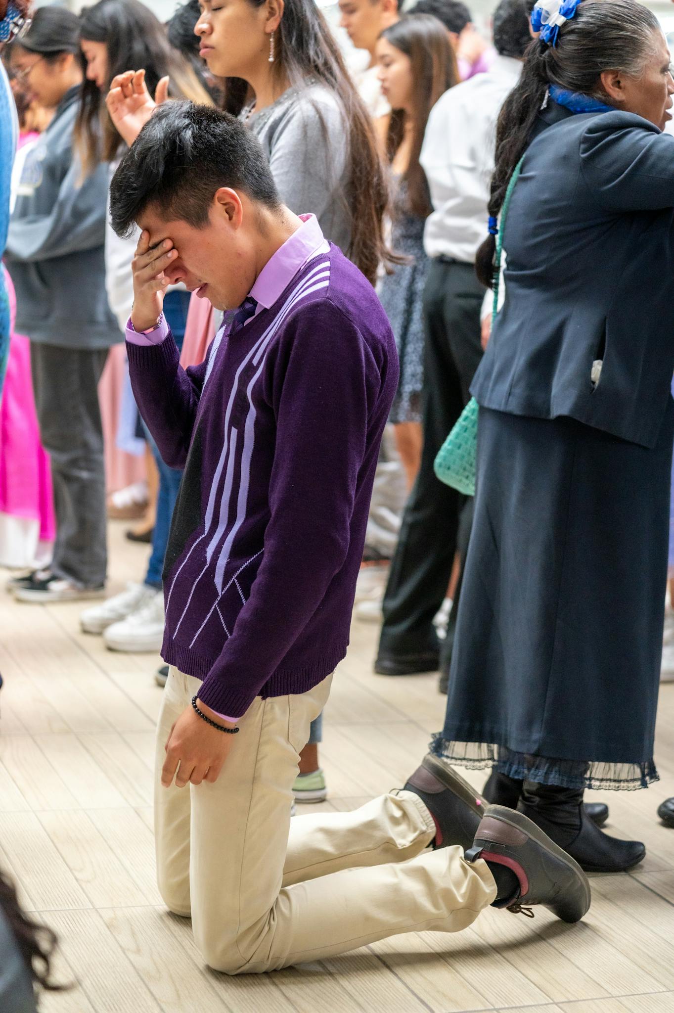 Photo par Israel Torres A man kneeling down in front of a crowd of people