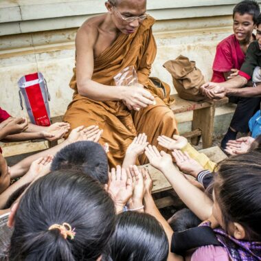 Monk Handing Towards Kids